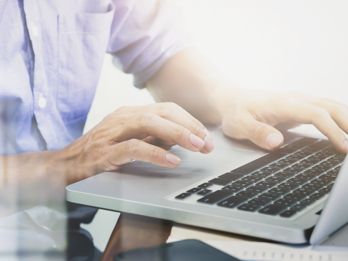 Man's hands typing on laptop keyboard