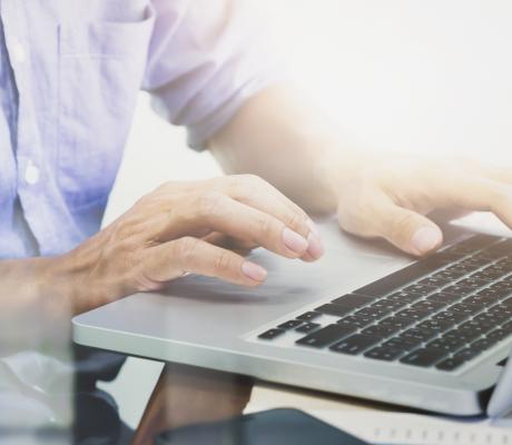 Man's hands typing on laptop keyboard