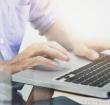 Man's hands typing on laptop keyboard